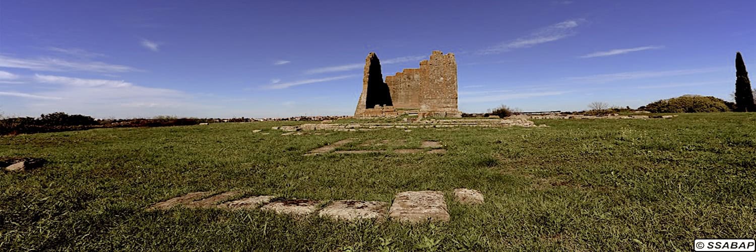 Rovine romane con torre in pietra su prato verde a Roma o dintorni